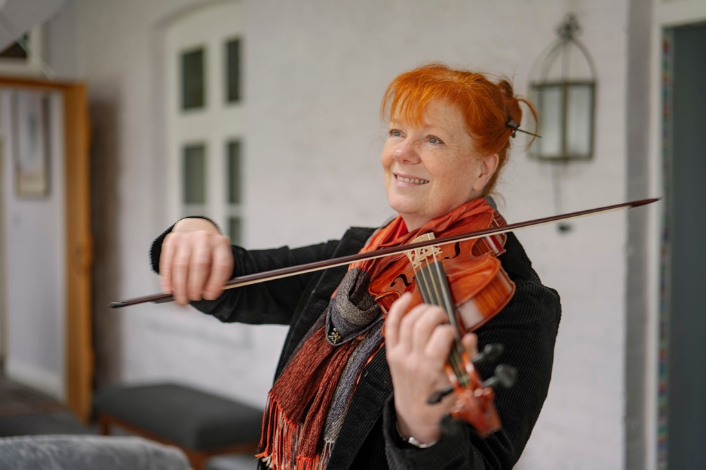 Gillian Taylor, a woman with red hair playing the violin